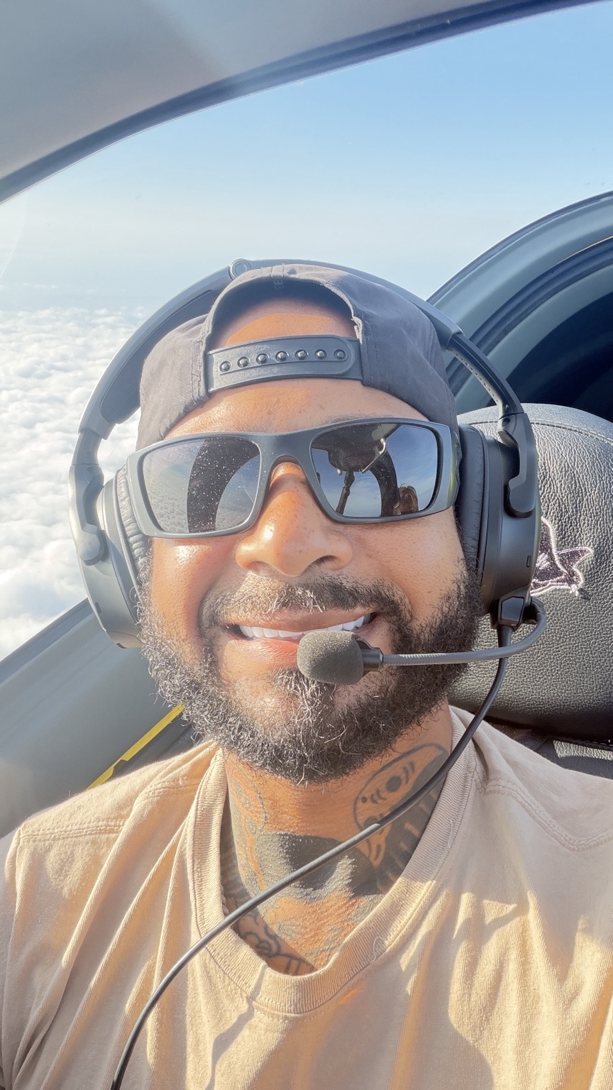 Romeo Toro seated in an aircraft cockpit wearing a pilot headset